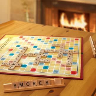 Scrabble board on a wooden table with letters spelling