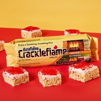 A package of crackleflame fire logs with hot cinnamon rice cereal treats on top of a red table.