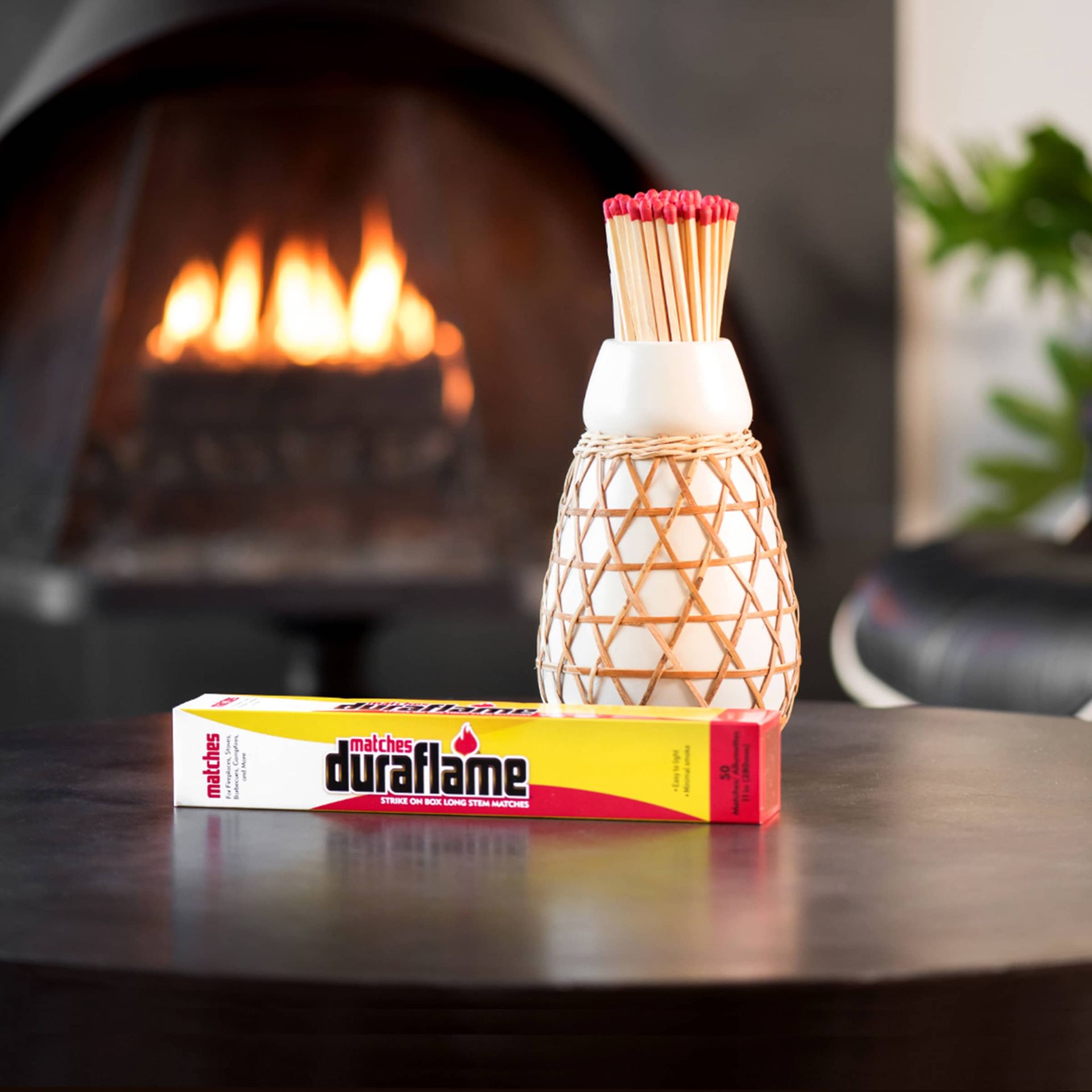 A box of duraflame long-stem safety matches sits on a table in front of a fireplace