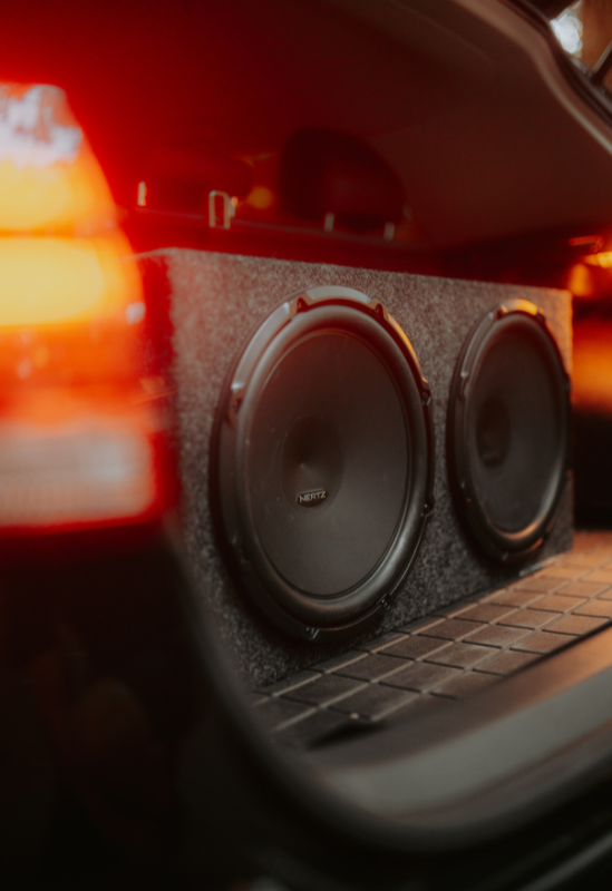 A close up of a speaker box in the back of a car.