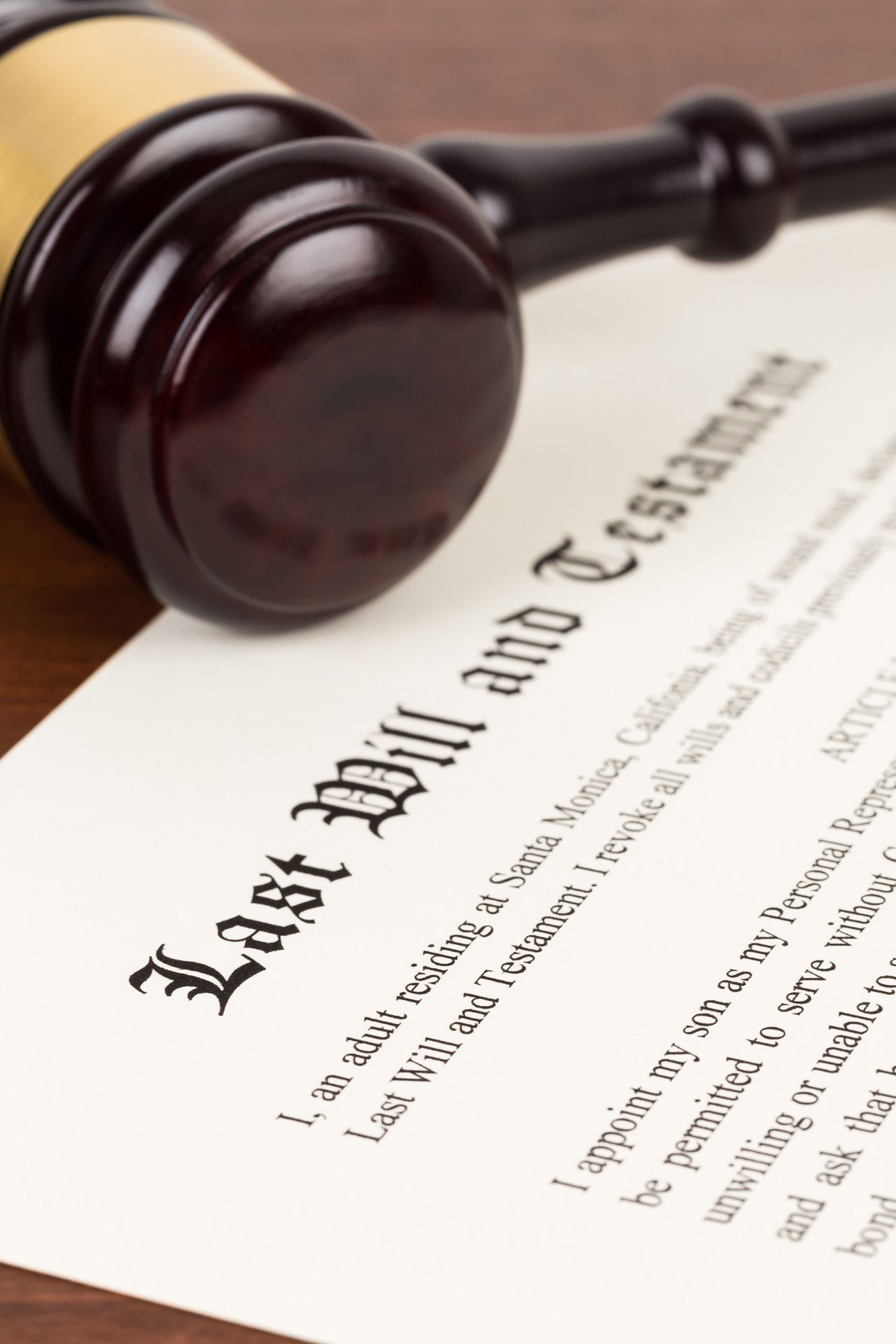 Gavel resting on a Last Will and Testament document on a wooden surface.