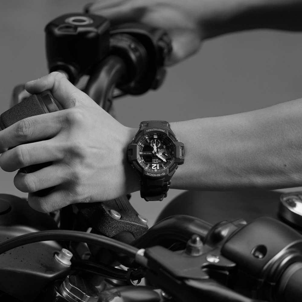 Black and silver wristwatch with a black face, black leather band, and rotating bezel.
