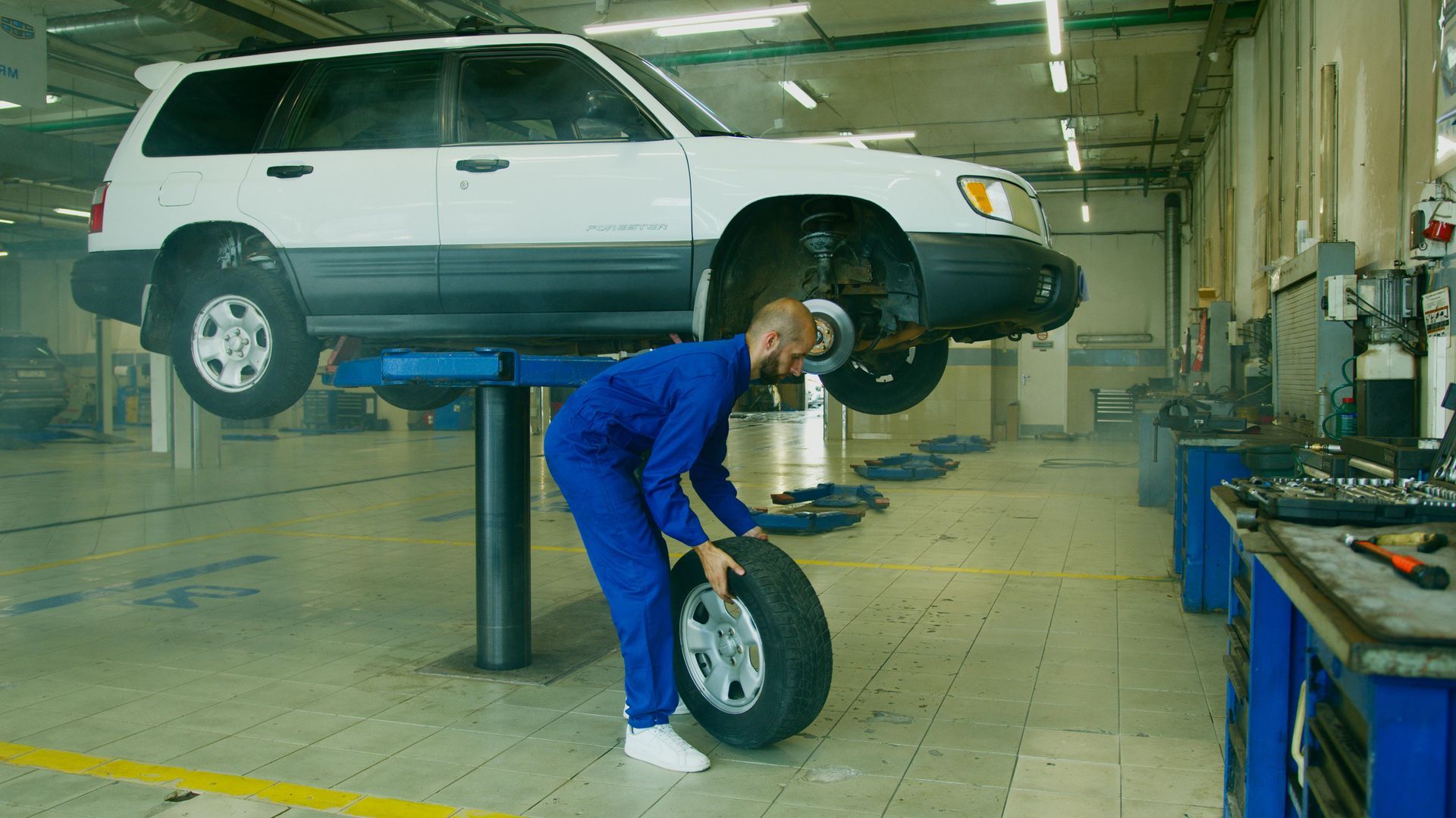 car on a lift replacing a tire | Super Service of Pomona Valley