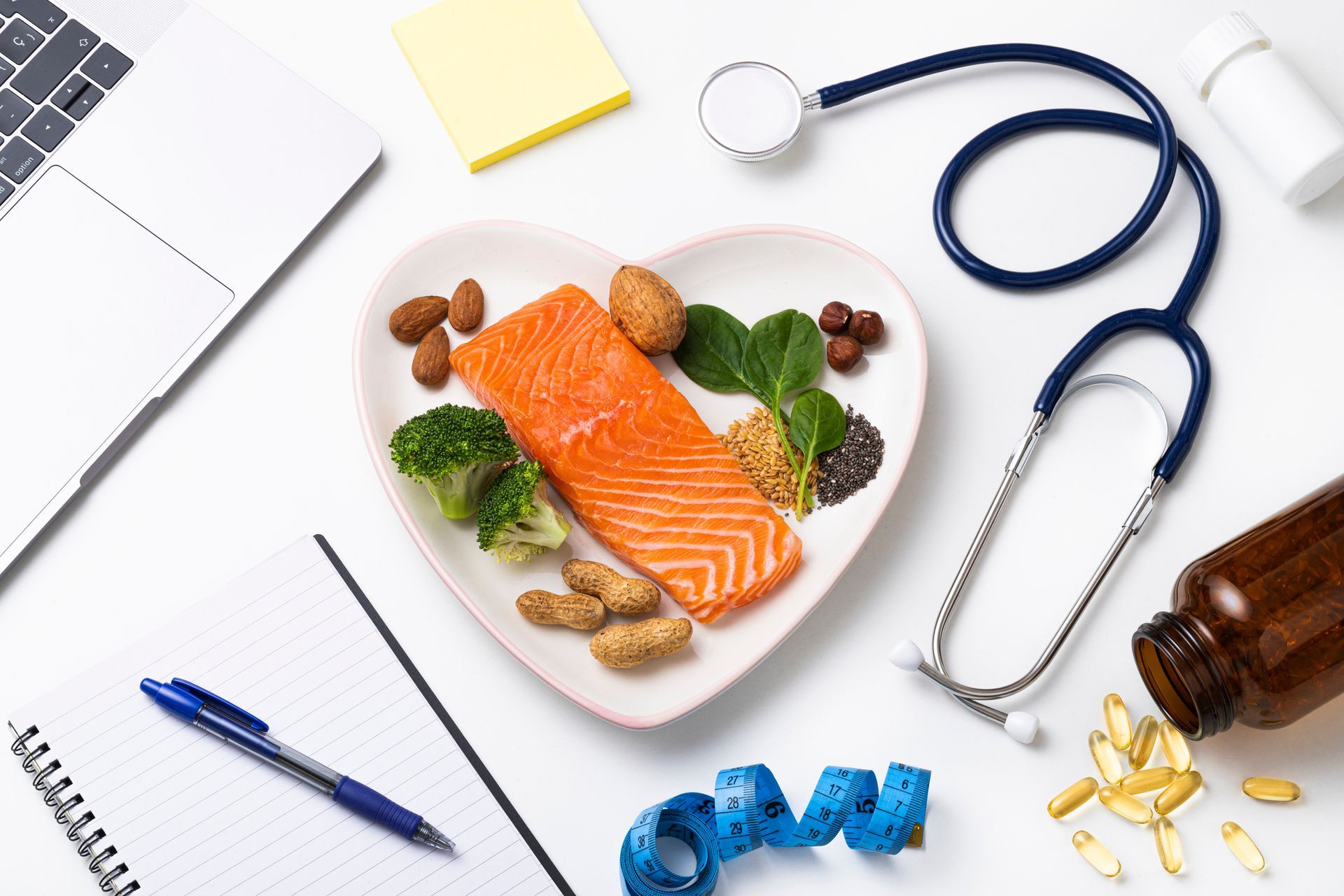 A plate of food in the shape of a heart next to a stethoscope and a laptop.