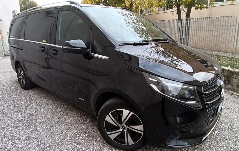 Un furgone Mercedes-Benz Classe V nero parcheggiato su una superficie ghiaiosa.