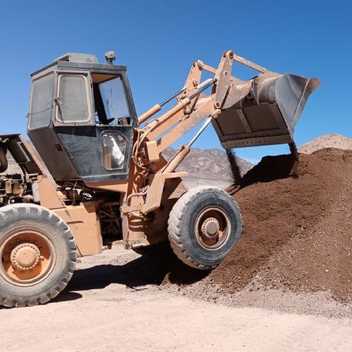 Una excavadora está cargando tierra en una pila