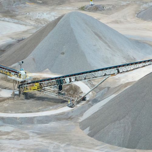 Una cinta transportadora pasa por una pila de grava