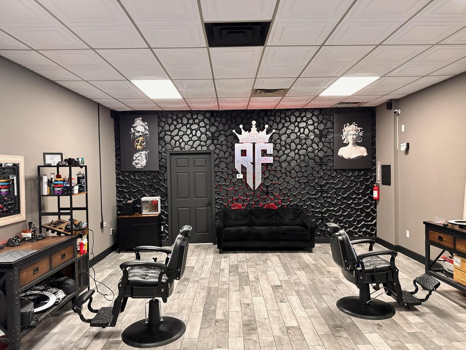 A barber shop with two barber chairs and a couch.