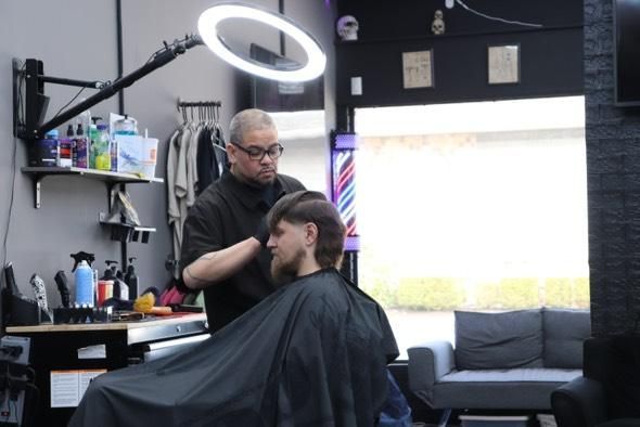 A man is getting his hair cut at a barber shop
