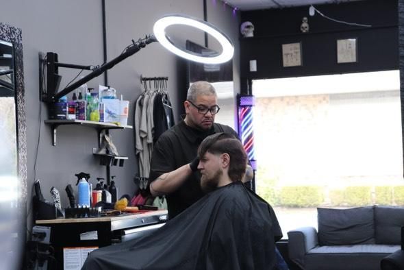 A man is getting his hair cut at a barber shop