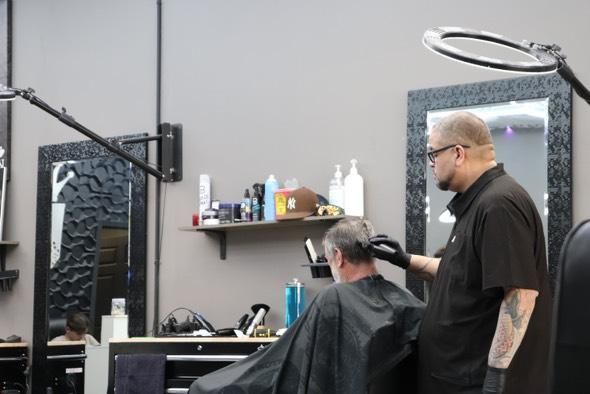 A man is getting his hair cut at a barber shop