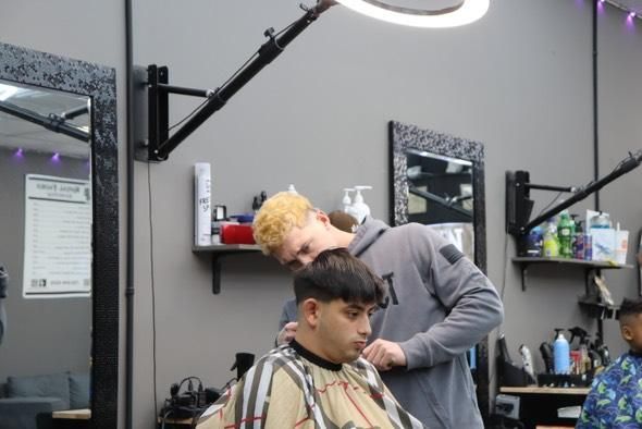 A man is getting his hair cut at a barber shop
