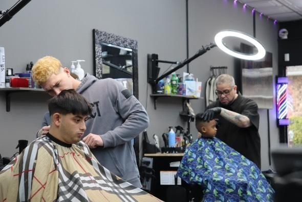 A man is getting his hair cut at a barber shop