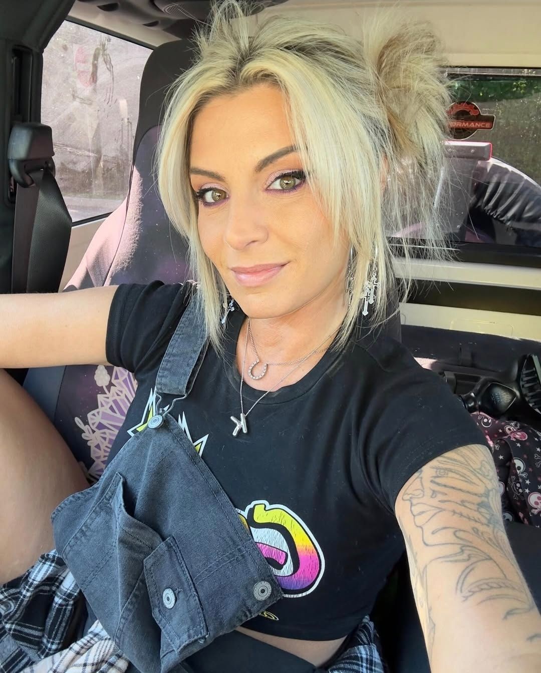 A woman is taking a selfie in the back seat of a car.