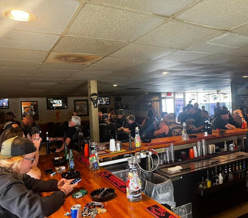 A group of people are sitting at a bar in a restaurant.