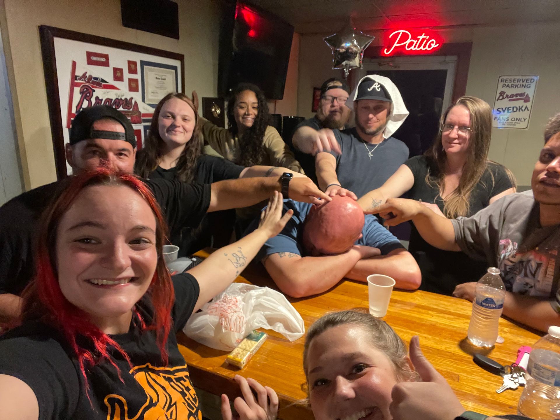 A group of people are sitting around a table in a bar.