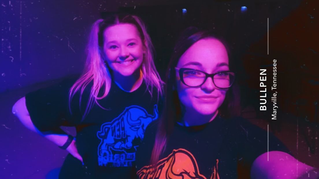 Two girls are posing for a picture and one of them is wearing a shirt that says bullpen