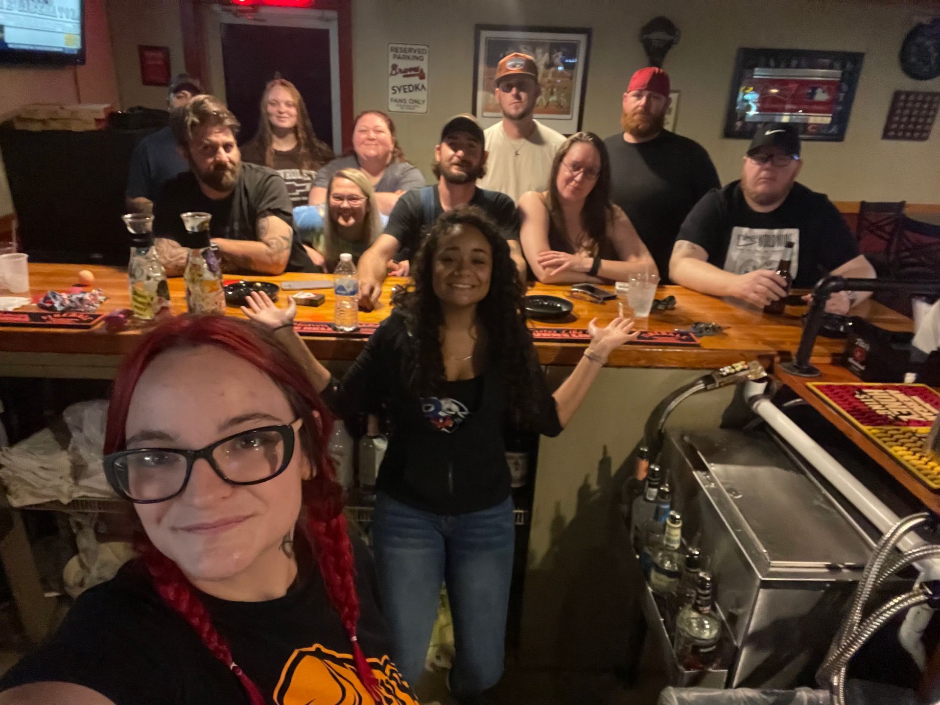 A group of people are posing for a picture in a bar.