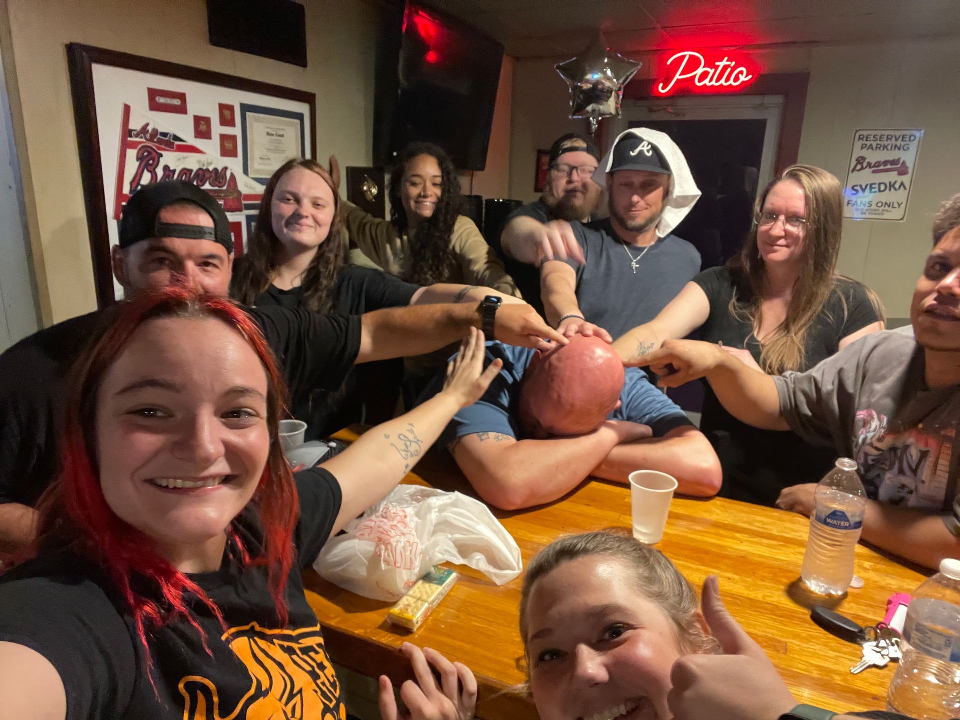 A group of people are sitting around a table in a bar.