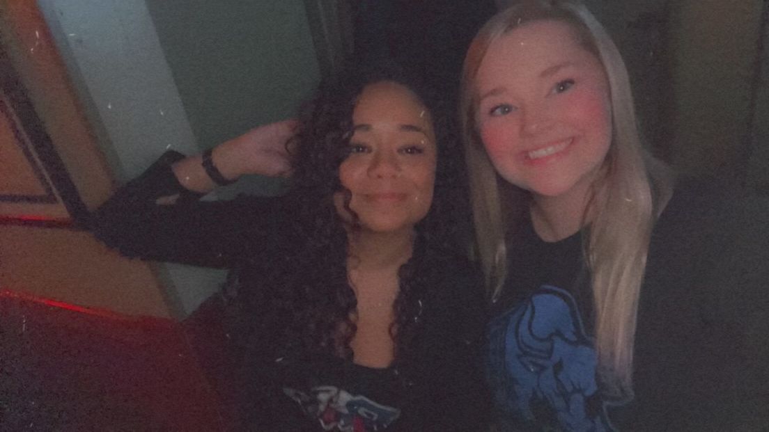 Two women are posing for a picture together and smiling for the camera.