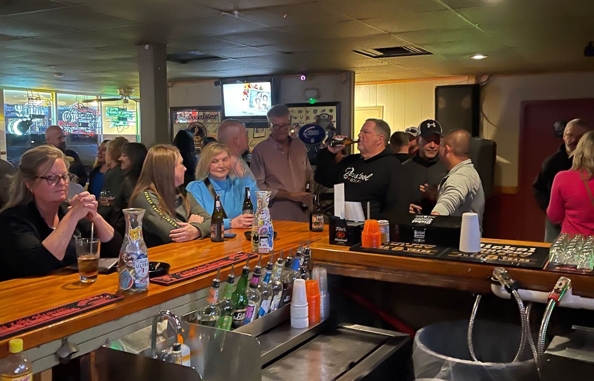 A group of people are sitting at a bar in a restaurant.