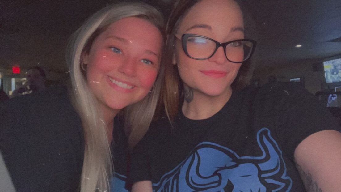 Two women are posing for a picture together and one of them is wearing glasses.