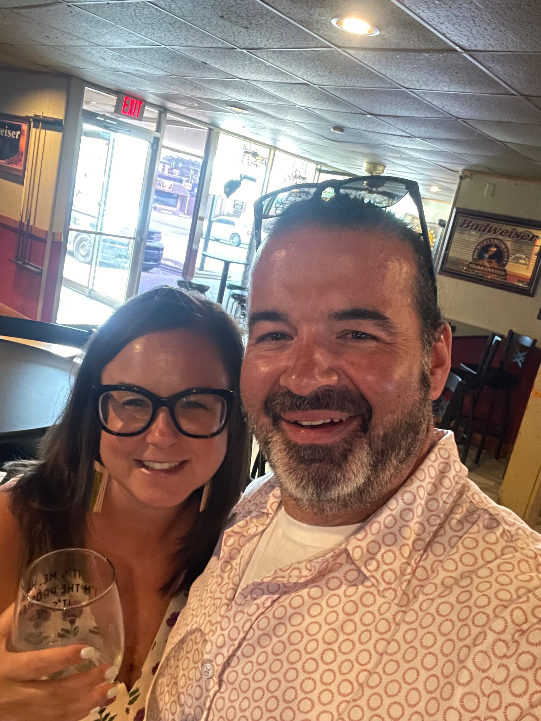 A man and a woman are posing for a picture in a restaurant.