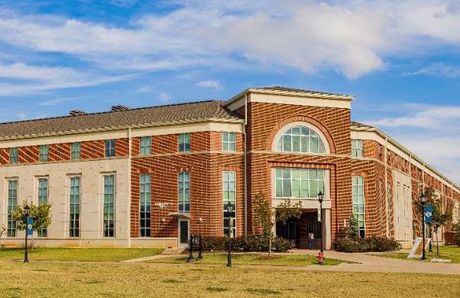 A large brick building with a lot of windows on a sunny day.