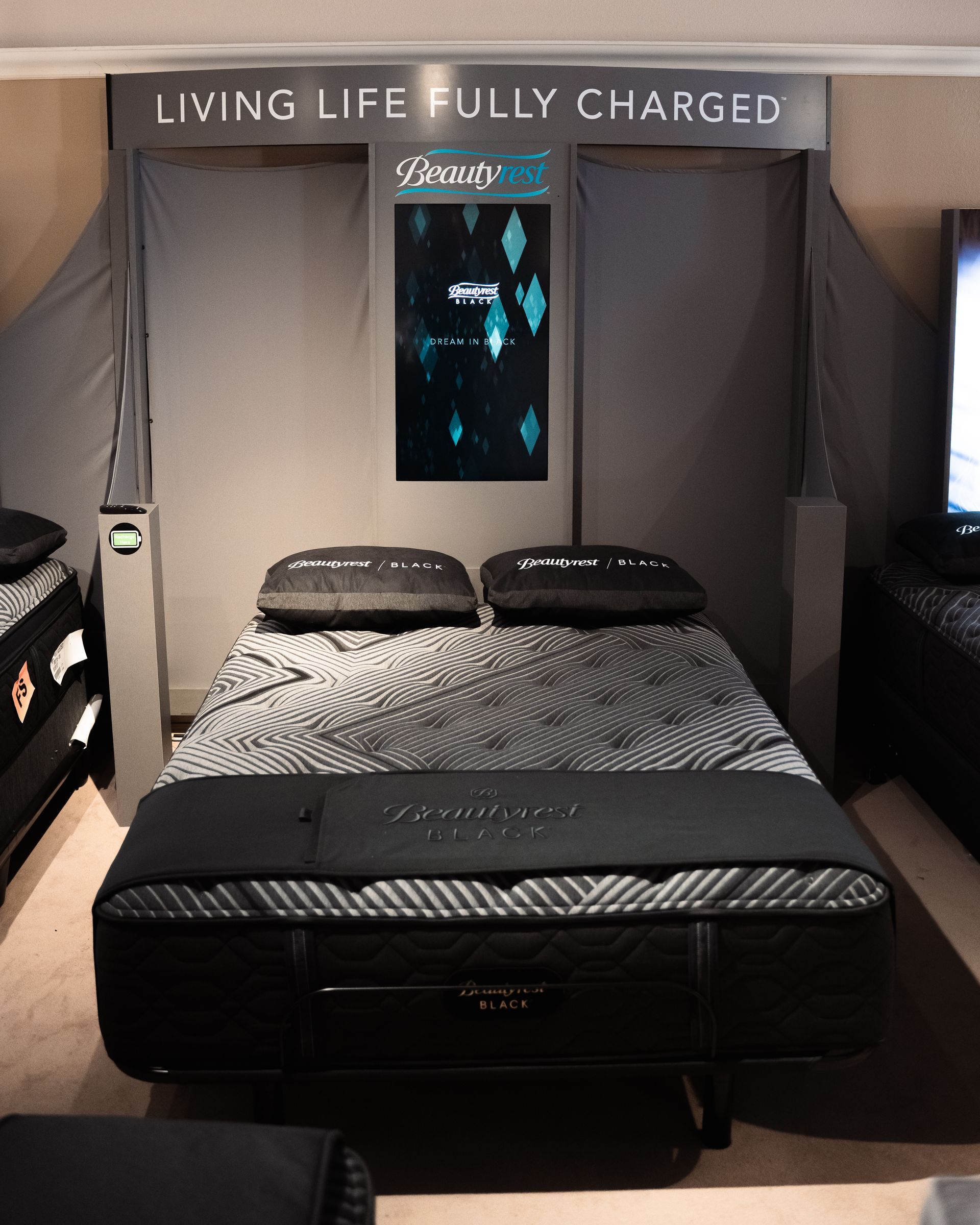 A bed with a sign that says living life fully charged