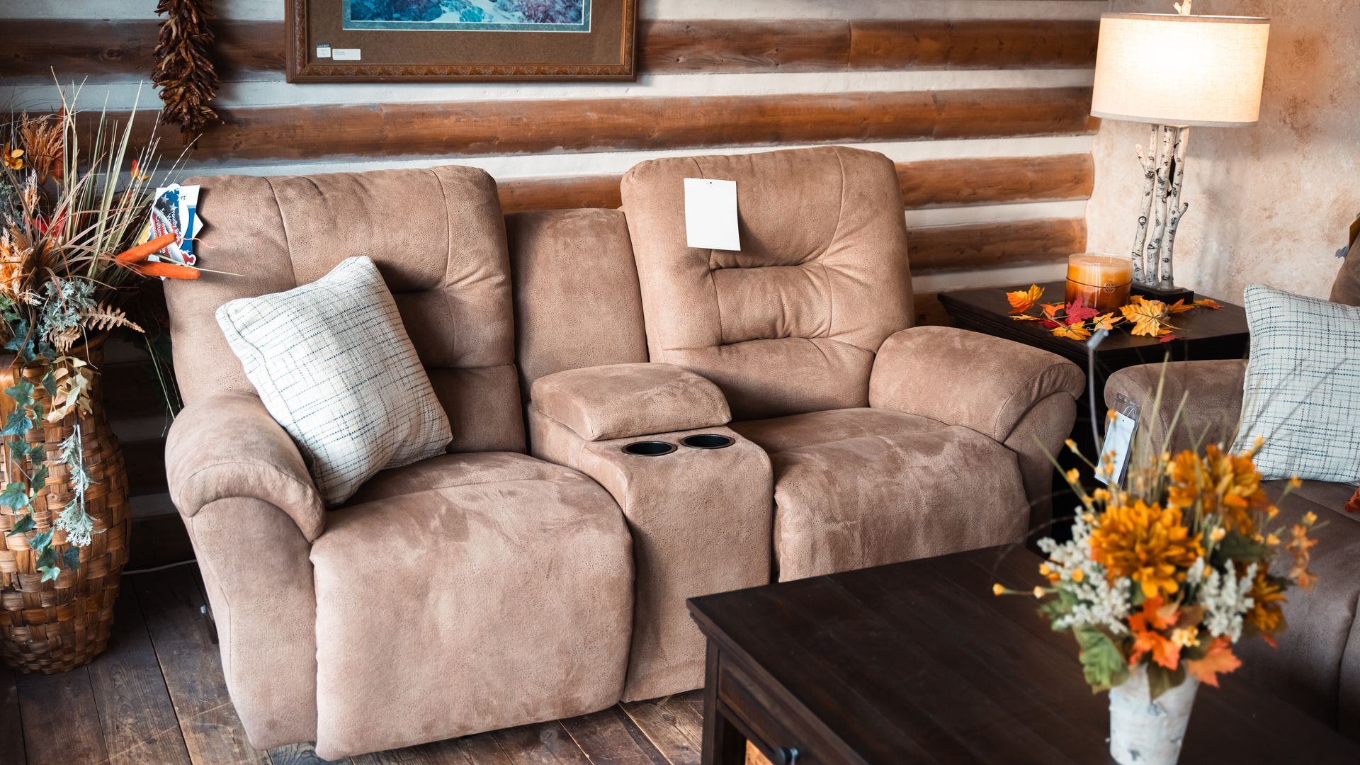 A living room with a couch , chair , table and vase of flowers.