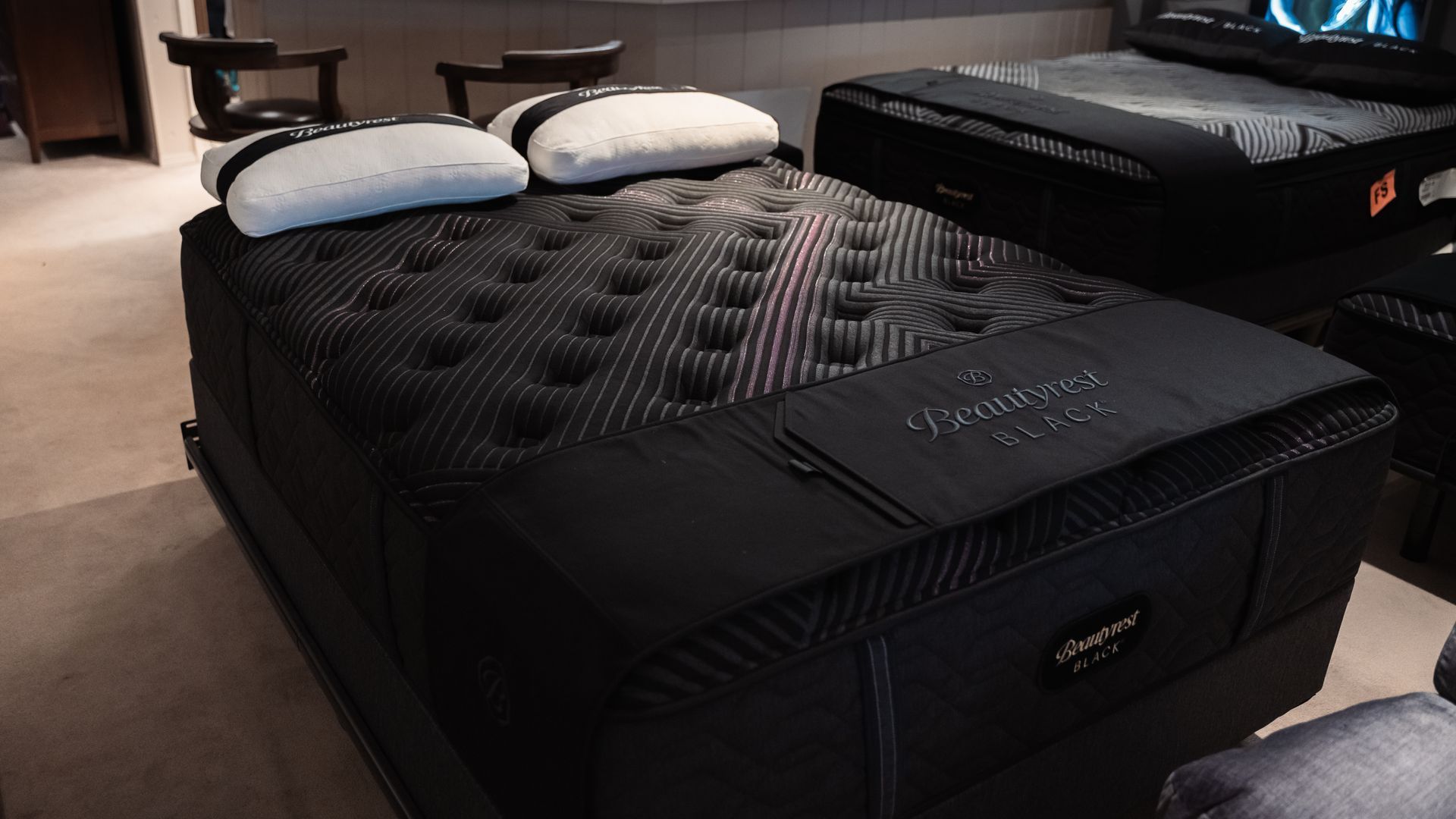 A black mattress is sitting on top of a bed in a room.