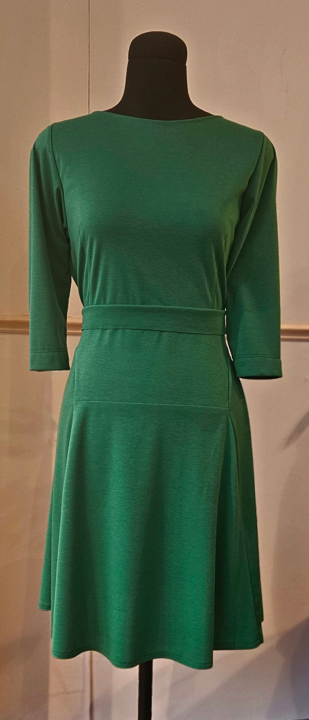 Een mannequin met een blauw jasje en een rode ketting