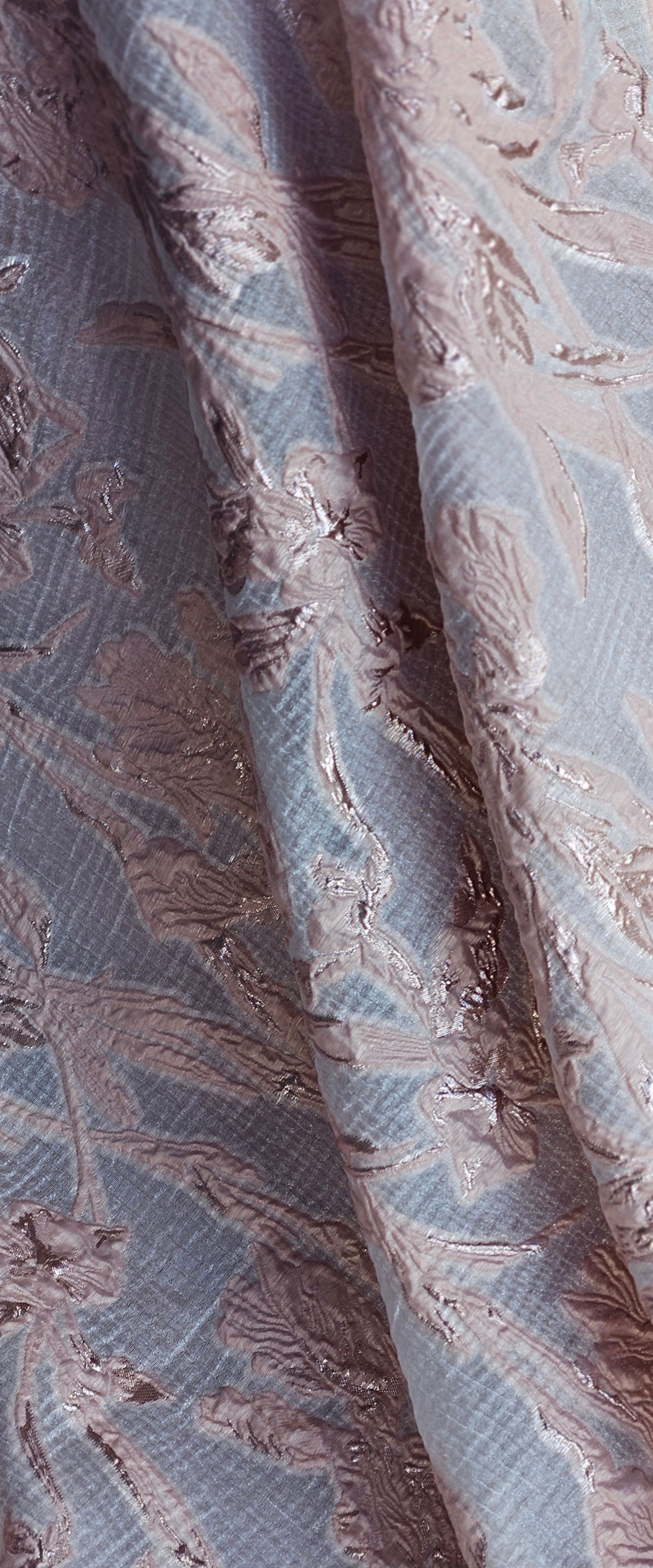 Een close-up van een blauw-zilveren stof met een patroon erop.