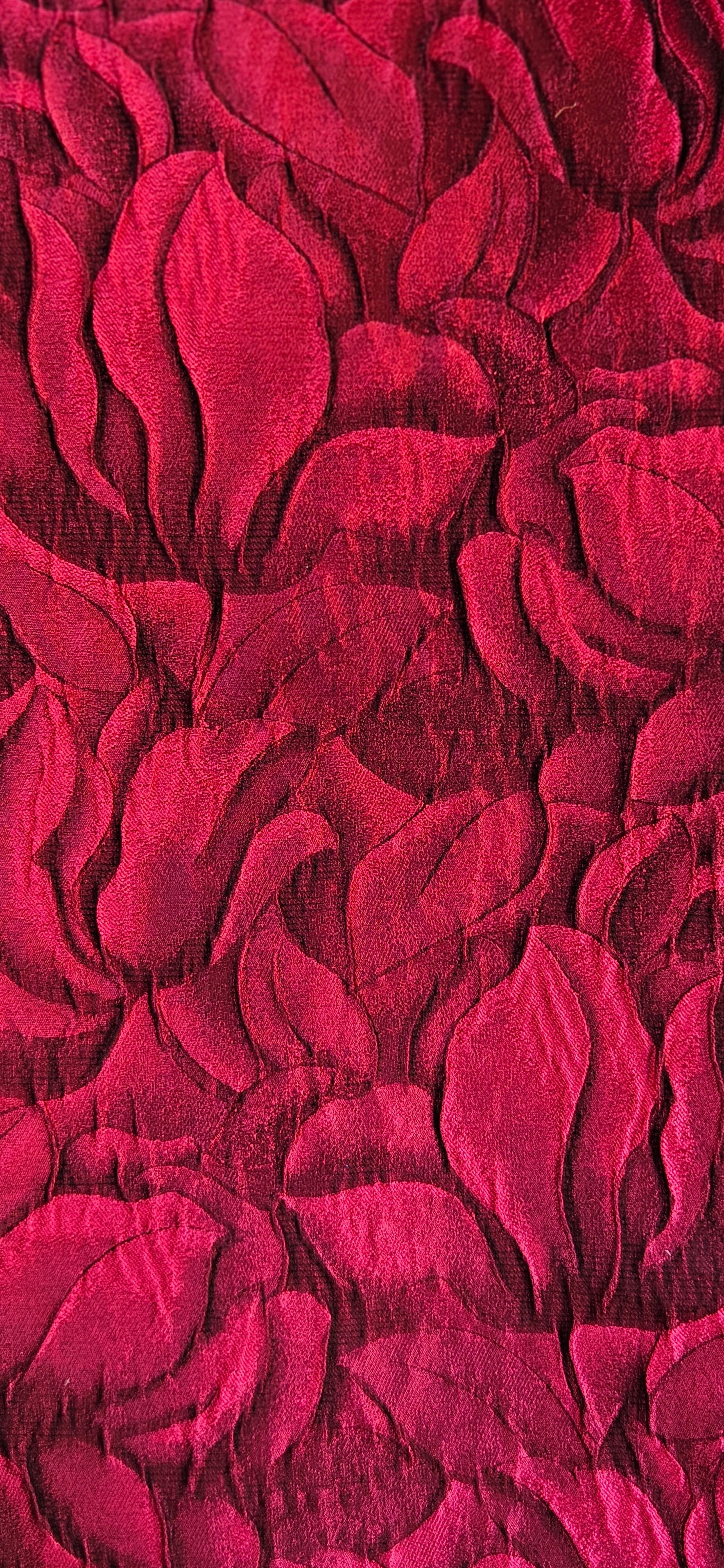 Een close-up van een rood stuk textiel  met bladeren-print