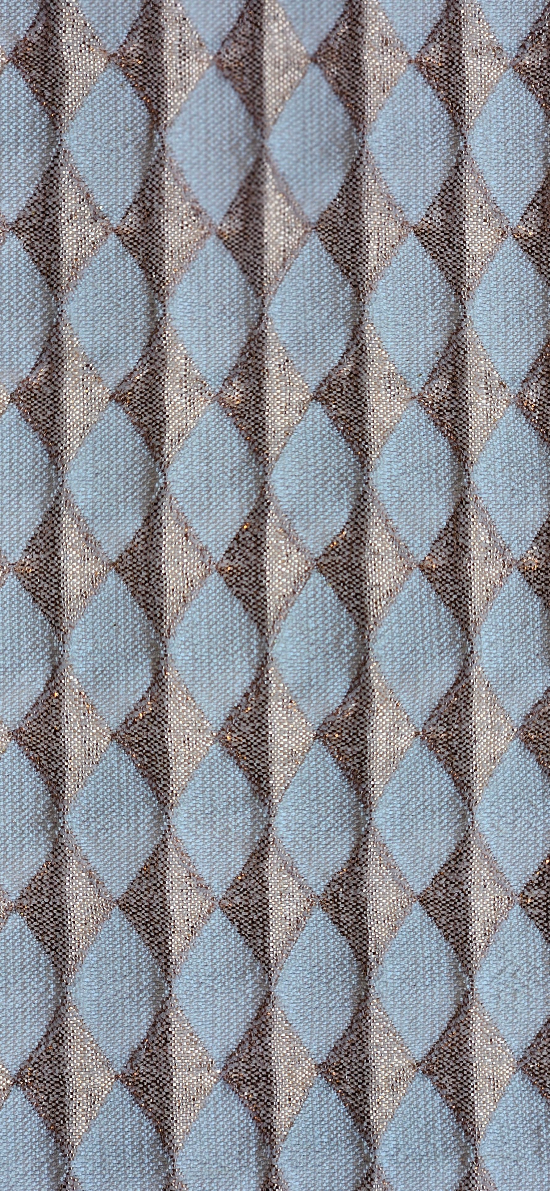 Een close-up van een stof met een zilveren ruitpatroon op een blauwe achtergrond.