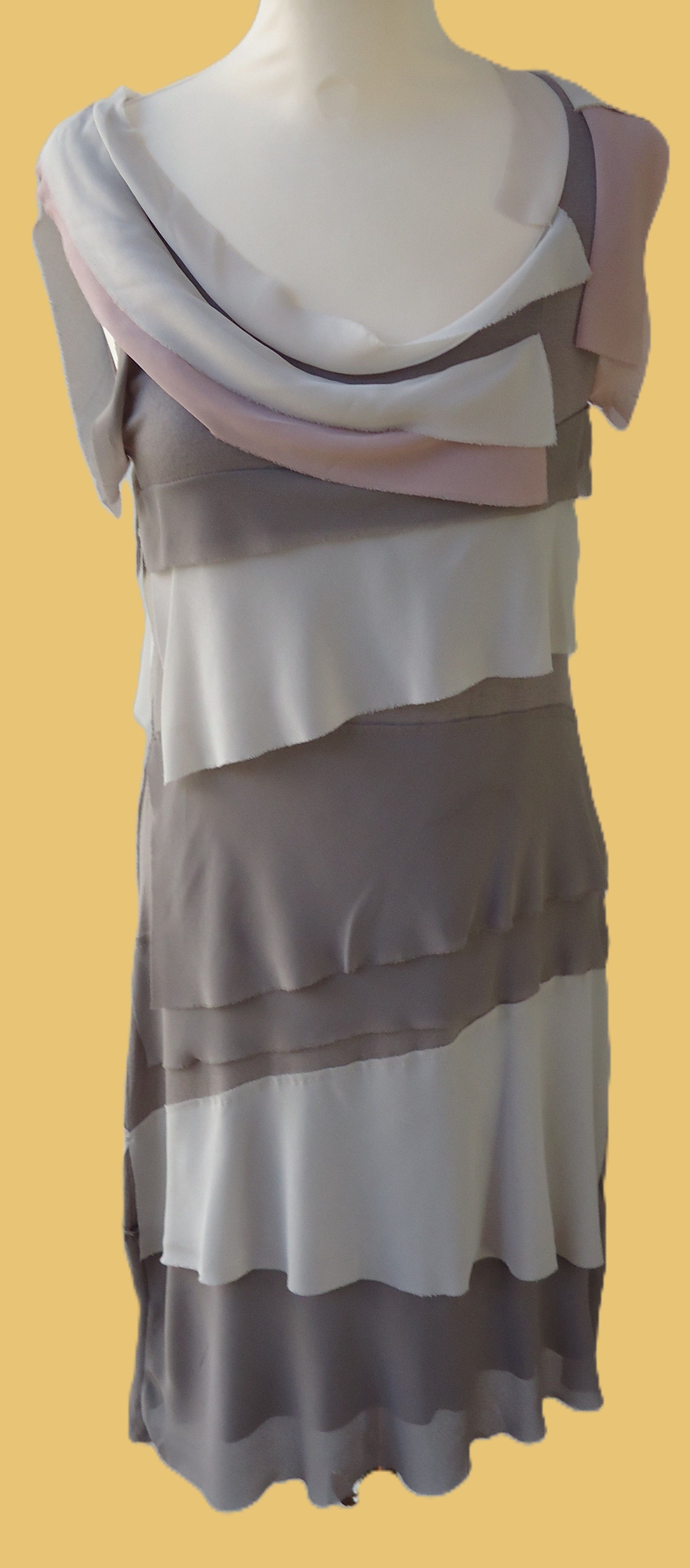 Een vrouw met groene jurk met  paarse strik op de rug.