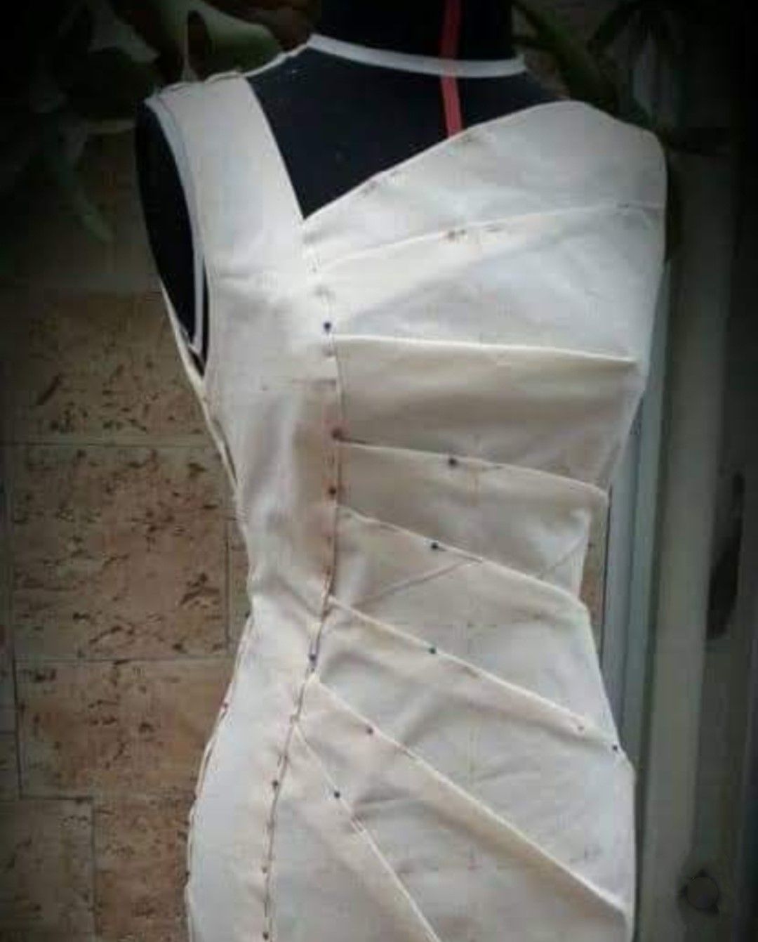 Er wordt een witte jurk gemaakt op een paspop.