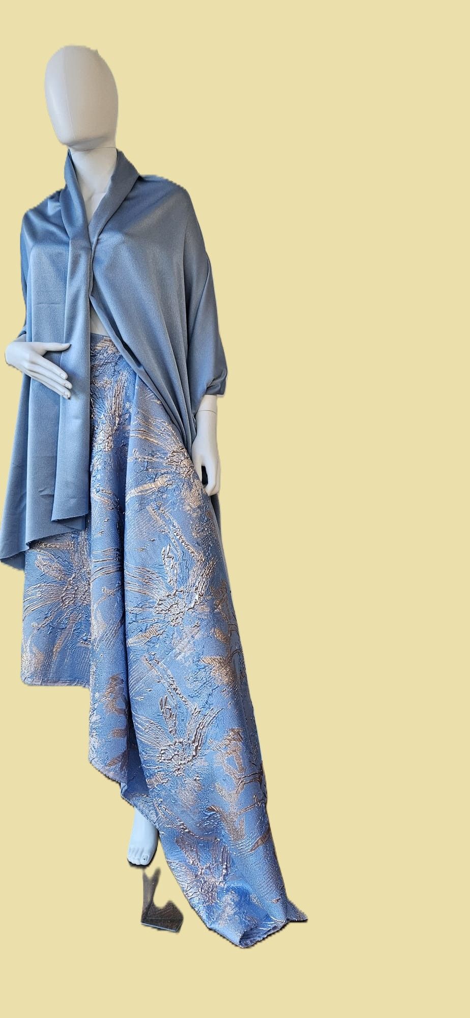 Een vrouw draagt ​​een feestelijke blauwe jurk en een blauw jasje