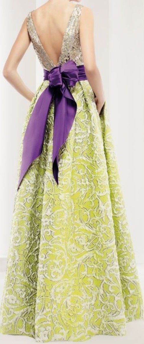 Een vrouw met groene jurk met  paarse strik op de rug.