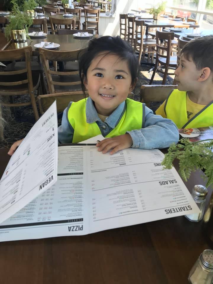 young girl at restaurant with menu