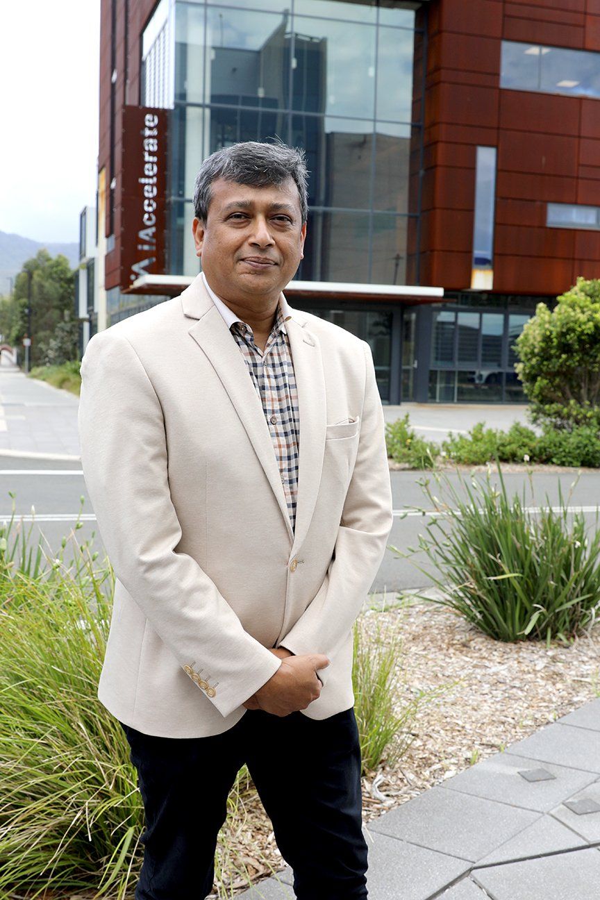 man wearing coat posing in front of building