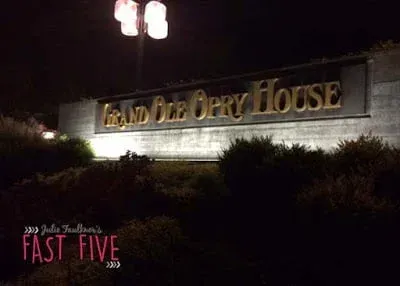 A large sign for grand ole opry house is lit up at night.