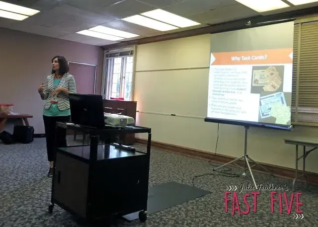 A woman is giving a presentation in front of a screen that says fast five