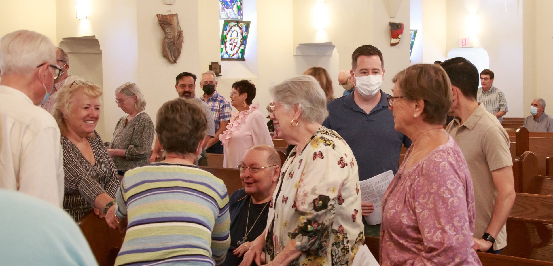 Parishioners greeting one another during the Peace of the People | Congregantes dándose la paz