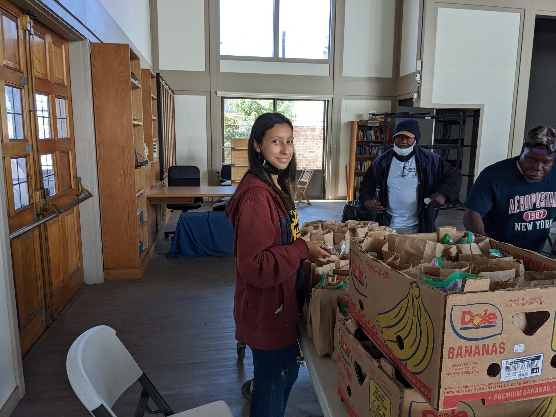 Manna Meals Volunteer distributing food to the homeless  | Voluntaria del almuerzo para las personas que viven en la calle