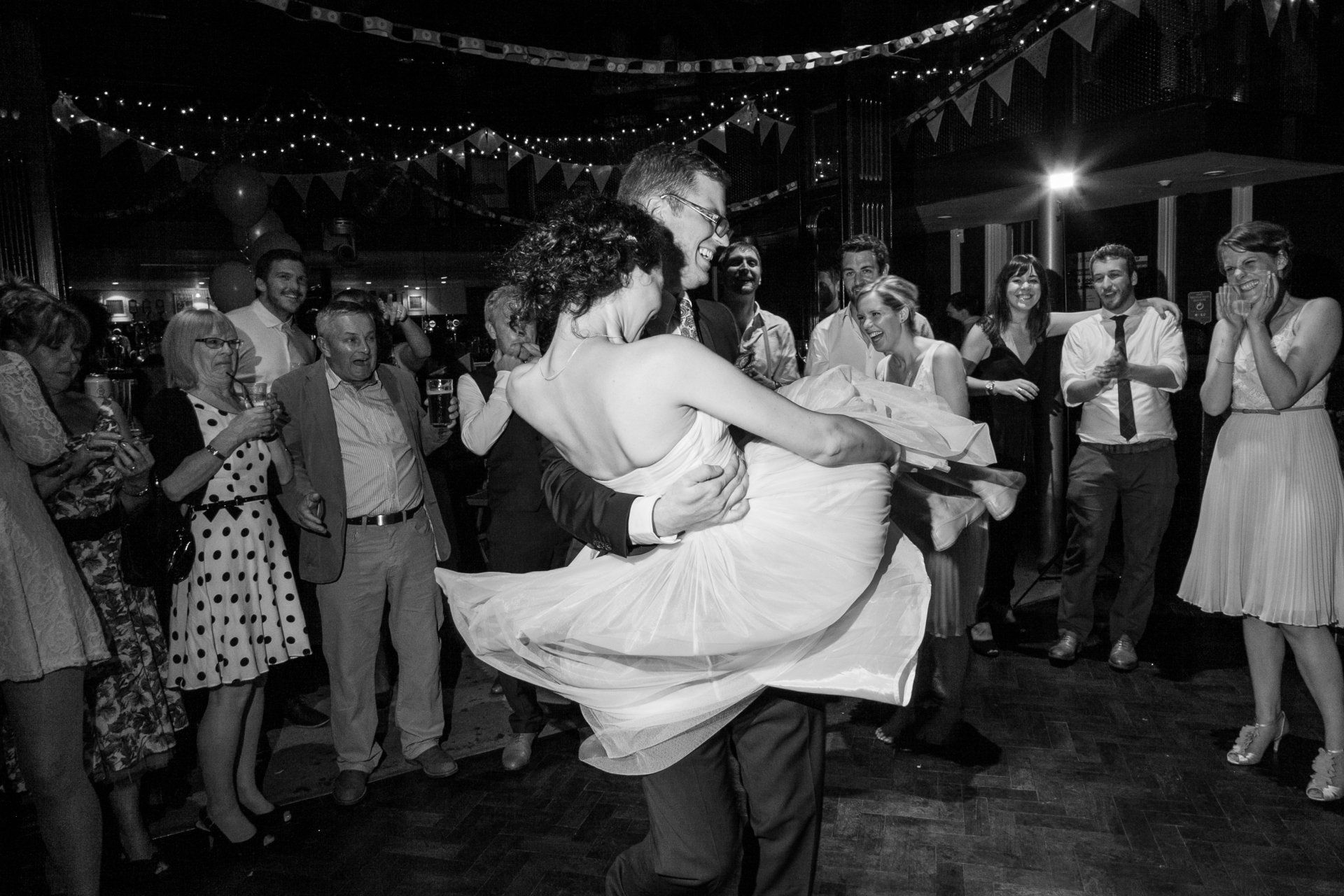 wedding at band on the wall groom picks bride up and spins during first dance