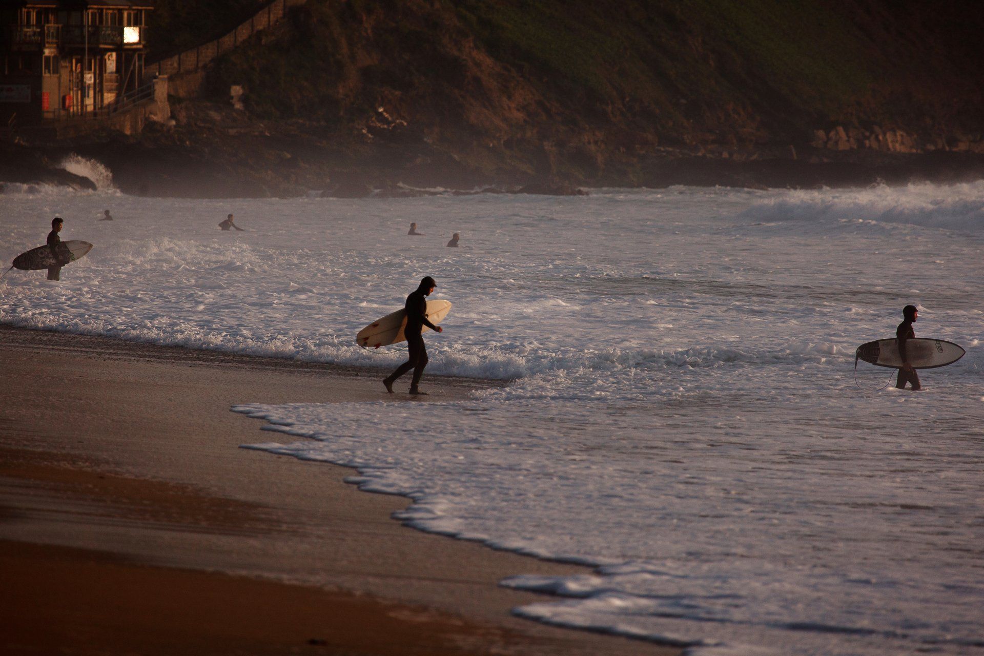 Cornwall surfers entering the water on fistral beach winter time