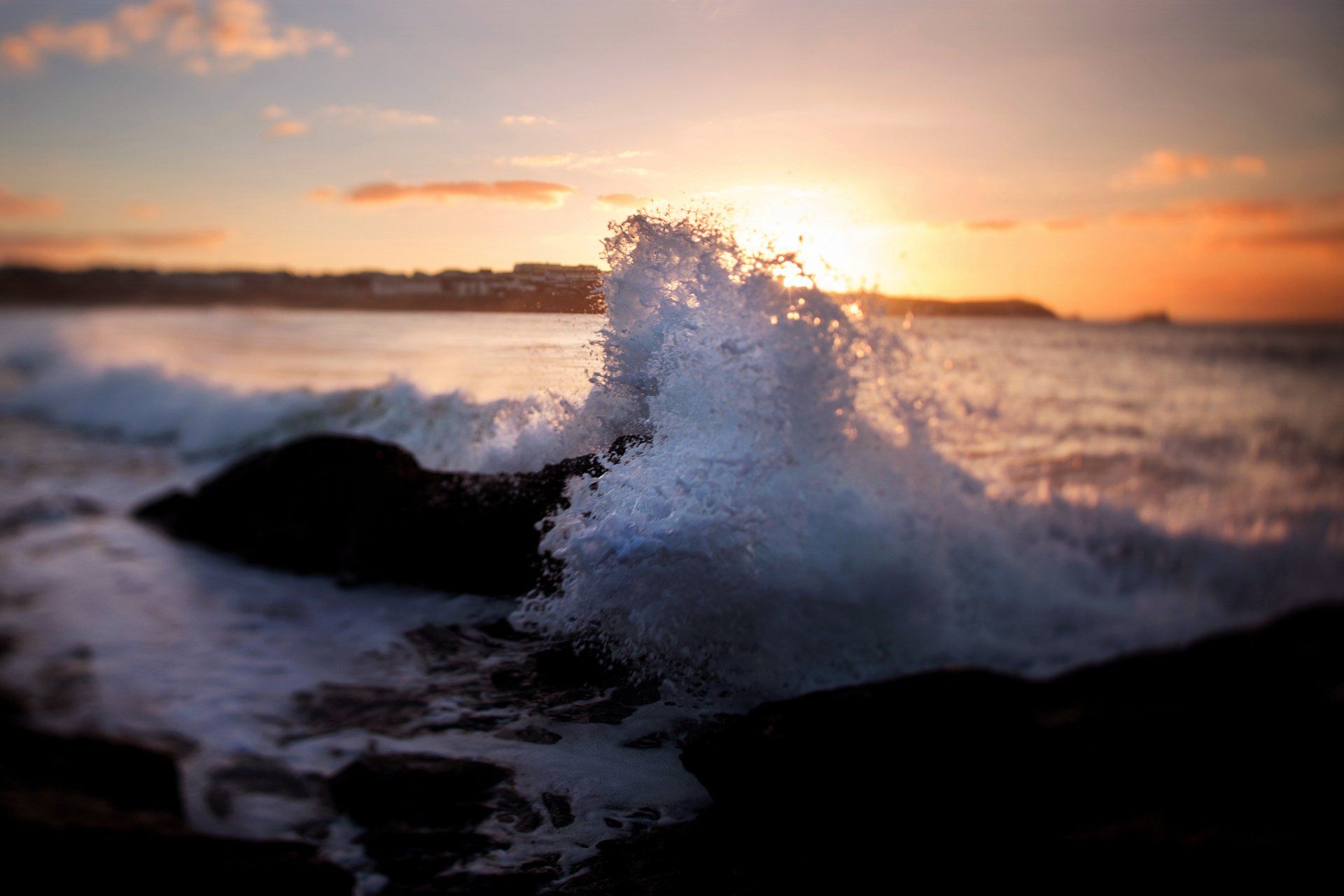 A wave slashing against the rocks on fisral beach