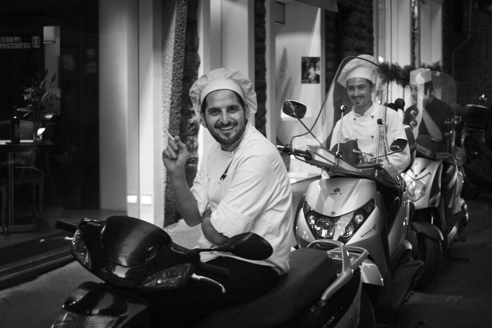 Black and white of three chefs sitting on scooters in Florence Italy