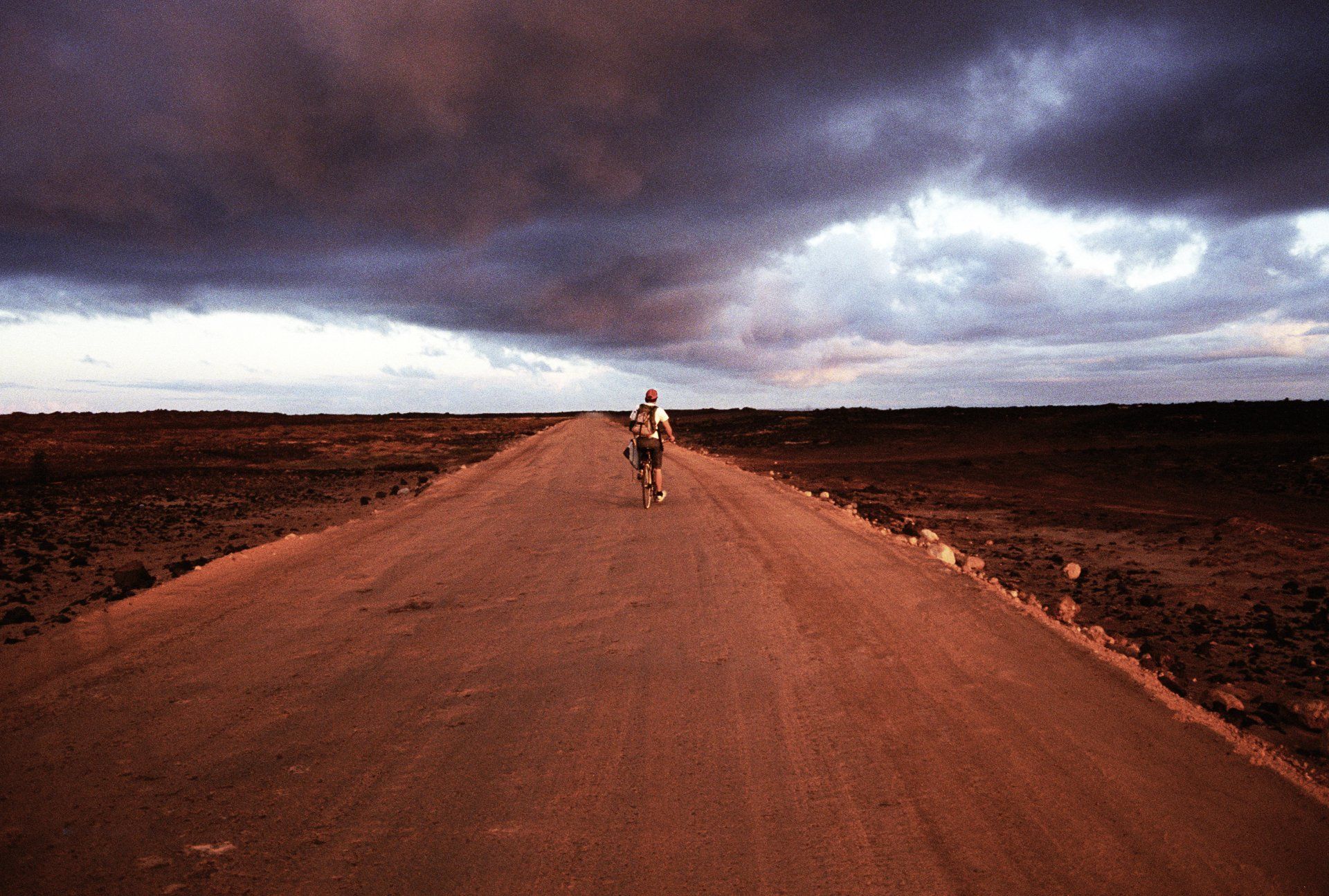surfer chris zinon rides bike on surf trip at dawn